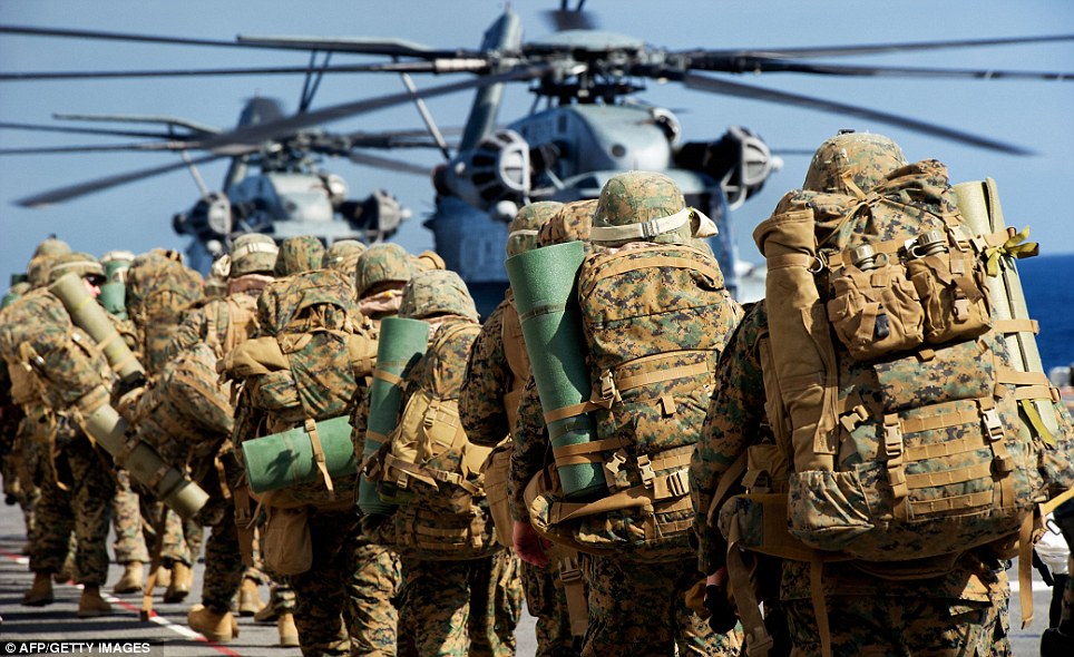 Kitted out: U.S. Marines board two helicopters as the initial landing stage of a week of war games exercises began yesterday